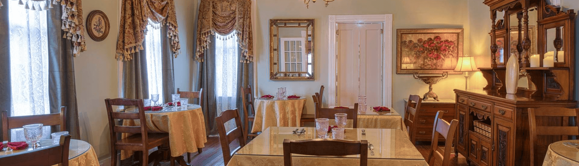 Dining room with multiple separate tables set with table linens.