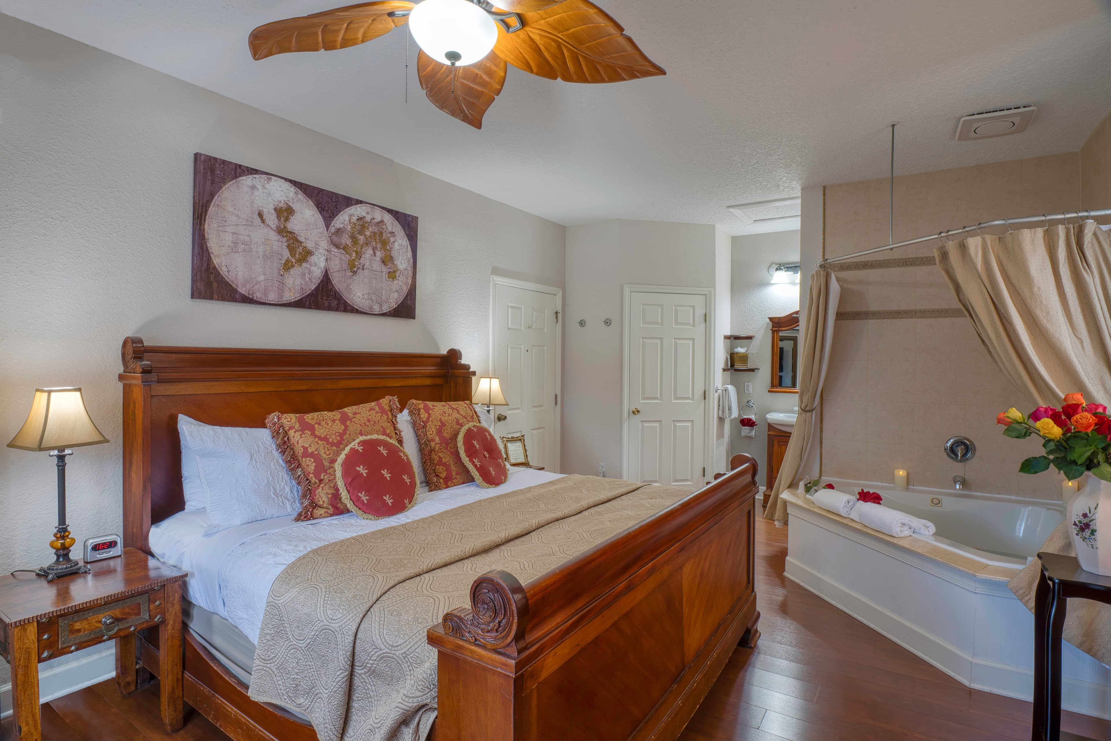 Romantic bedroom with king bed, hardwood floors, and in-room two-person Jacuzzi tub with shower