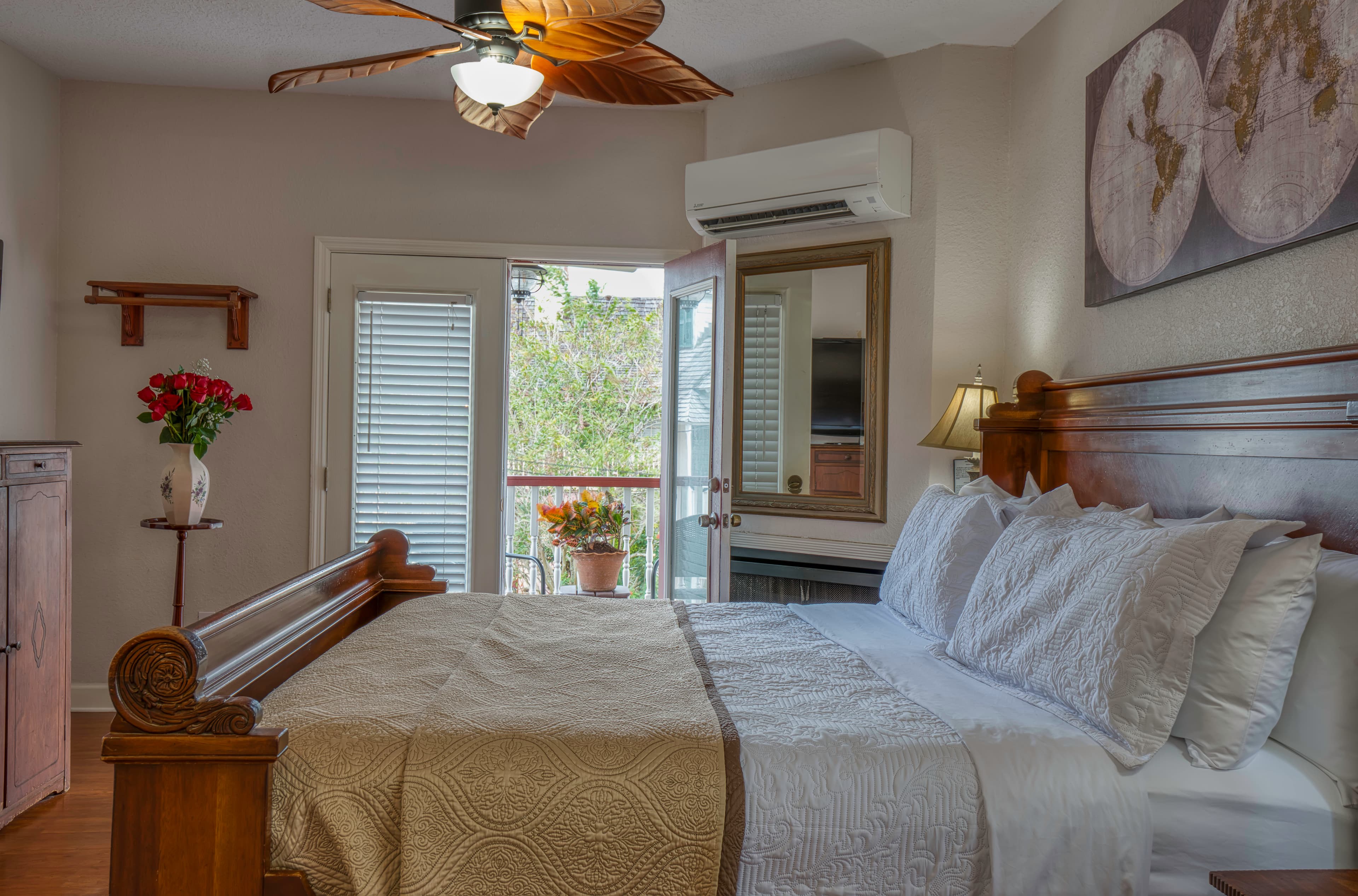 King bed in foreground, patio doors leading to second floor balcony