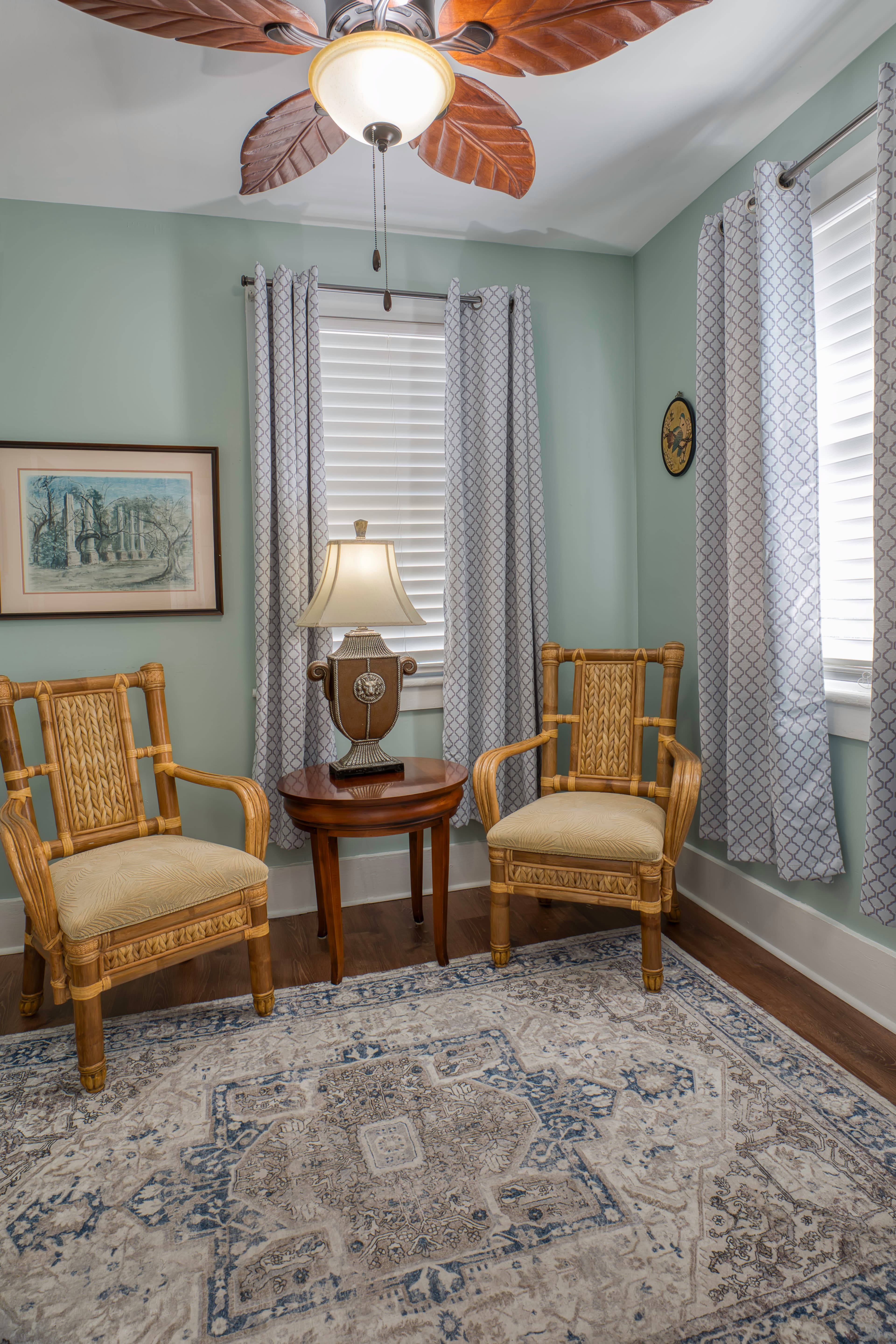 Sitting area with two armchairs, an occasional table with lamp, and oriental area rug