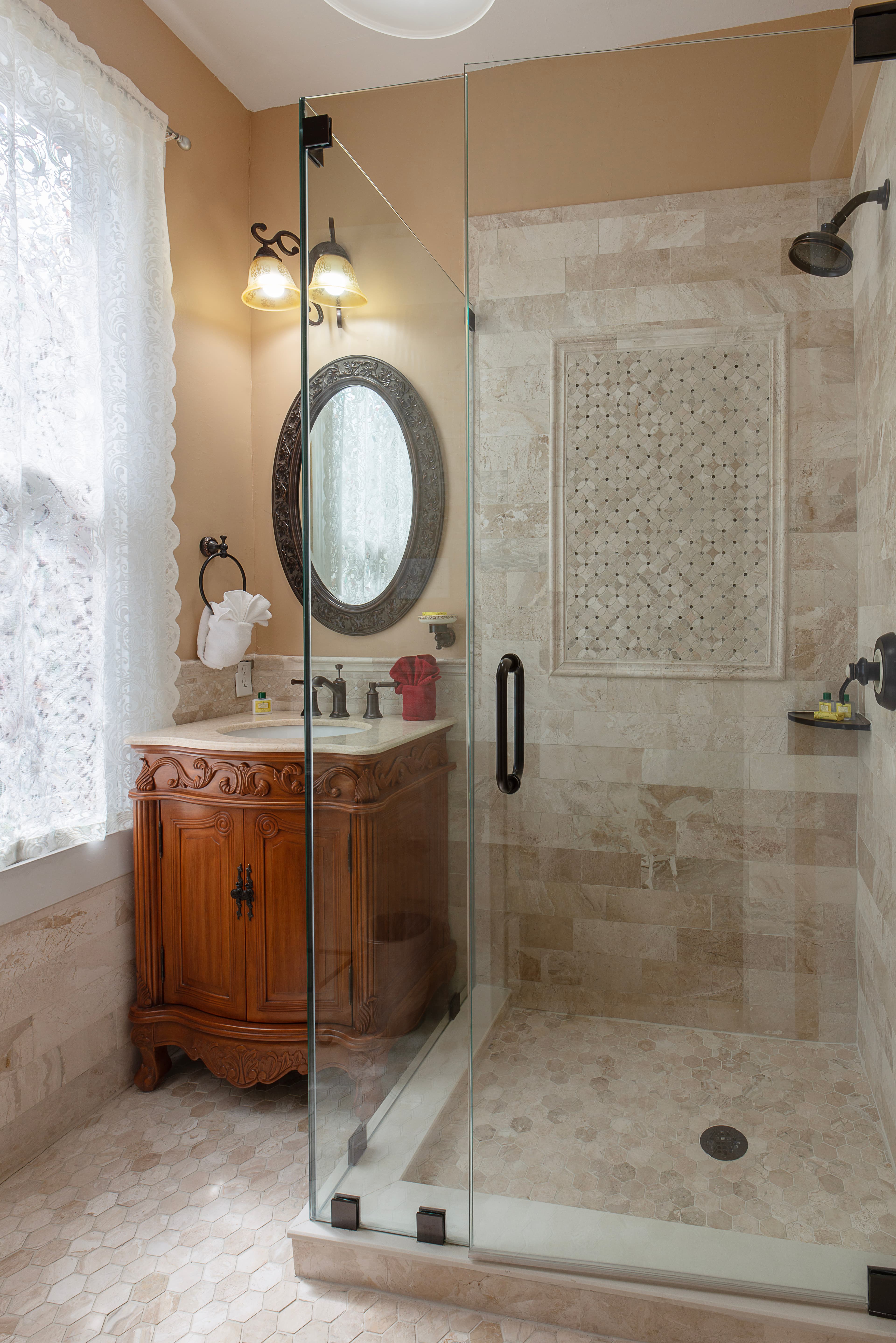 Bathroom with sink, mirror, and walk-in, tiled, glass-enclosed shower