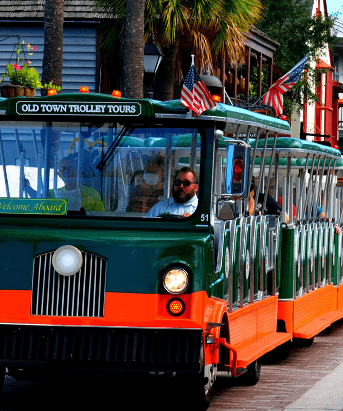 St. Augustine trolley bus in green and orange on a historic street