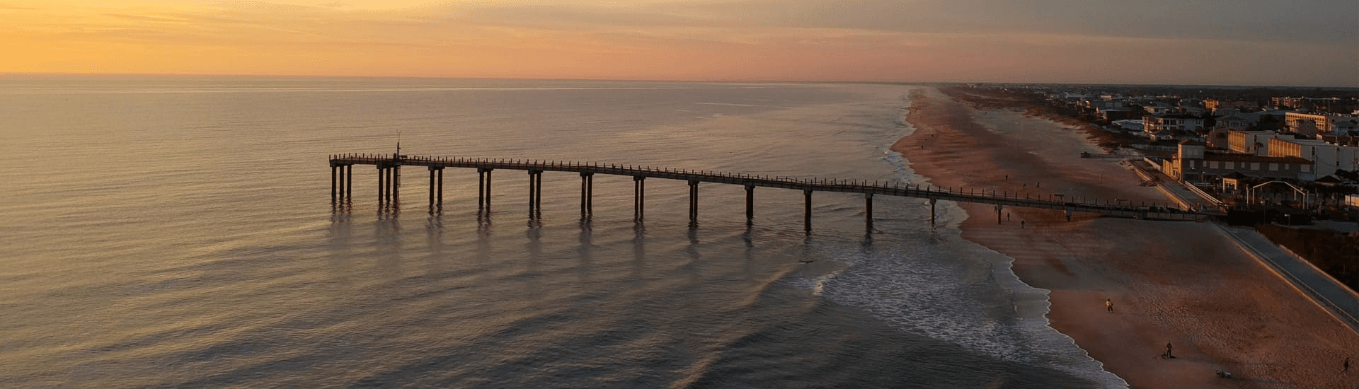 Pier running out into the ocean at sunset