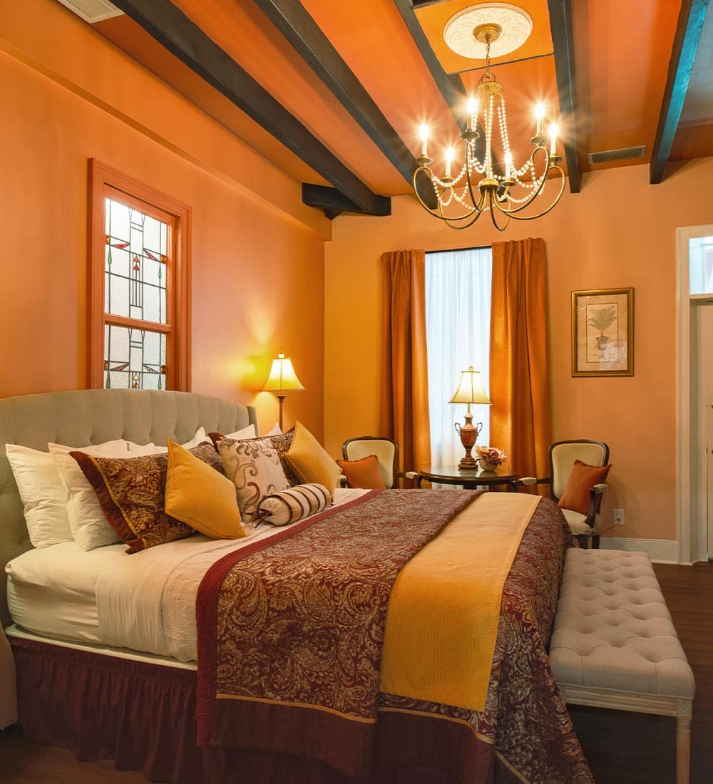 Cozy bedroom featuring an orange color scheme, a plush bed, and stylish furnishings.